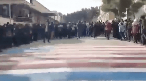 Studenten im Iran weigern sich, auf die amerikanische und israelische Fahne zu treten