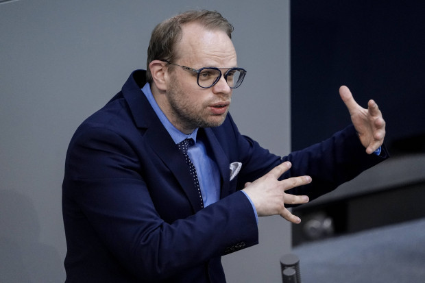 SPD-Politiker Helge Lindh bekämpft die Flut mit einem Sandsack